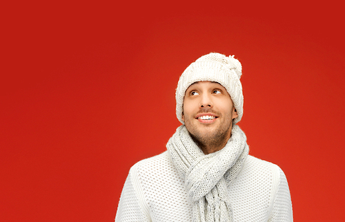 people, christmas, fashion, season and clothing concept - handsome man in winter wear over red background