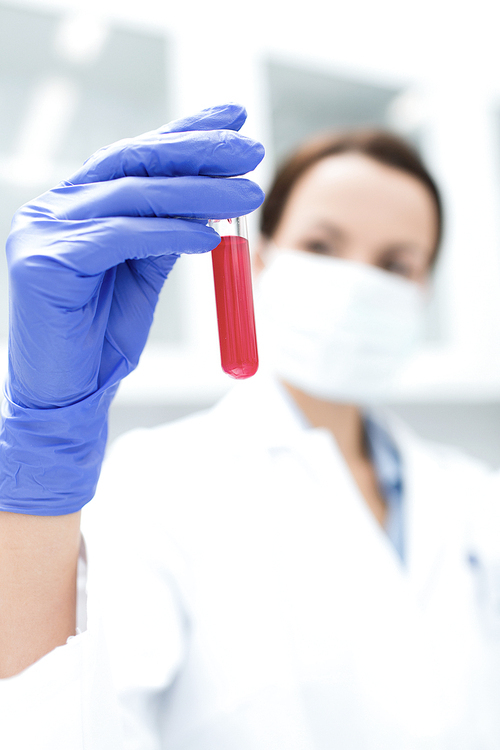 science, chemistry, biology, medicine and people concept - close up of young female scientist holding test tube with blood sample making research in clinical laboratory