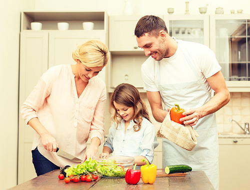 food, family, hapiness and people concept - happy family making dinner in kitchen