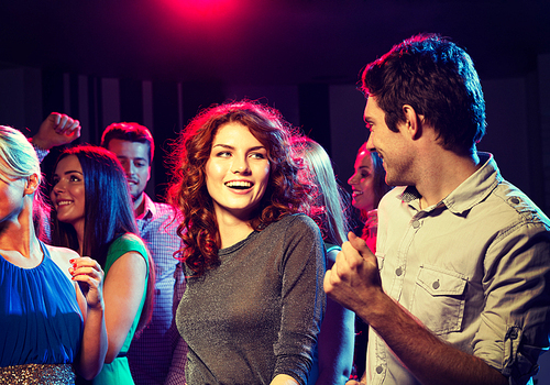 party, holidays, celebration, nightlife and people concept - smiling friends dancing in club