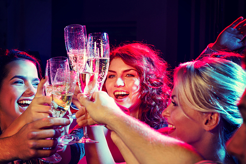 party, holidays, celebration, nightlife and people concept - smiling friends with glasses of champagne in club