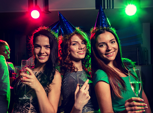 party, holidays, celebration, nightlife and people concept - smiling friends with glasses of champagne in club