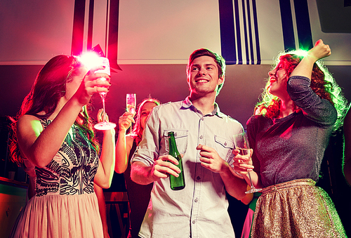 party, holidays, celebration, nightlife and people concept - smiling friends clinking glasses of champagne and beer in club