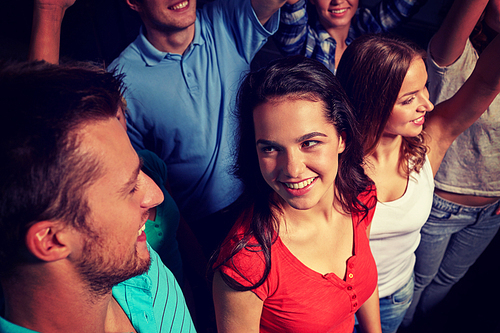 party, holidays, celebration, nightlife and people concept - smiling friends waving hands at concert in club