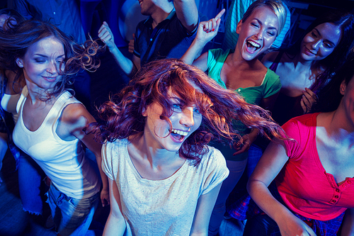 party, holidays, celebration, nightlife and people concept - smiling friends dancing in club