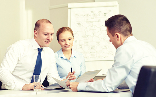 business, people and teamwork concept - smiling business team with papers meeting in office