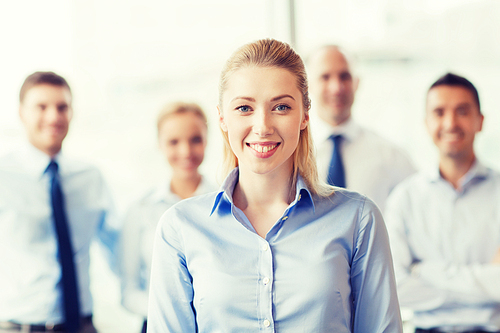 business, people and teamwork concept - smiling businesswoman with group of businesspeople in office