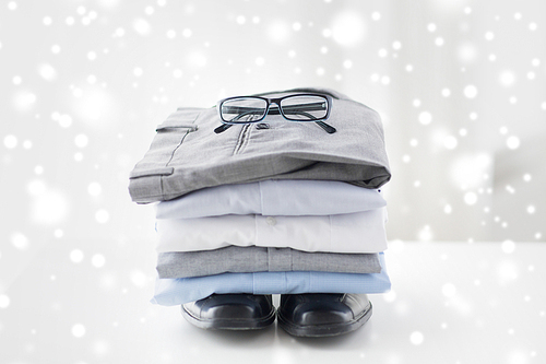 business, style, clothes, housekeeping and objects concept - close up of ironed and folded shirts and formal shoes on table at home over snow effect