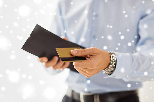 people, business, finances and money concept - close up of businessman hands holding open holding wallet and credit card over snow effect