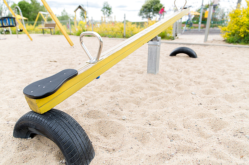 childhood, equipment and object concept - close up of swing or teeterboard on playground outdoors
