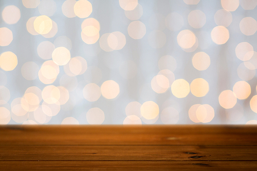 holidays, new year and celebration concept - close up of empty wooden surface or table over christmas golden lights background