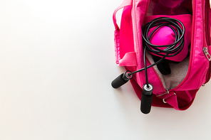 sport, fitness, healthy lifestyle and objects concept - close up of female sports stuff in bag and skipping rope