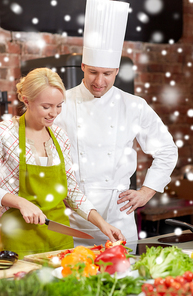 cooking class, culinary, food and people concept - happy male chef cook with woman cooking in kitchen over snow effect