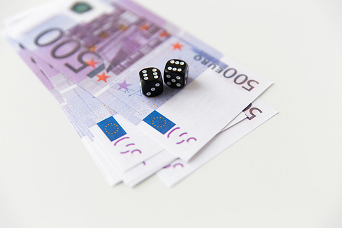casino, gambling and fortune concept - close up of black dice and euro cash money