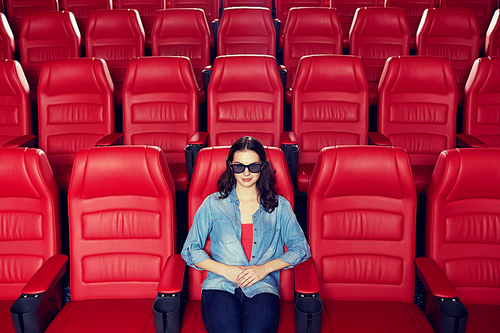 cinema, technology, entertainment and people concept - young woman with 3d glasses watching movie alone in empty theater auditorium