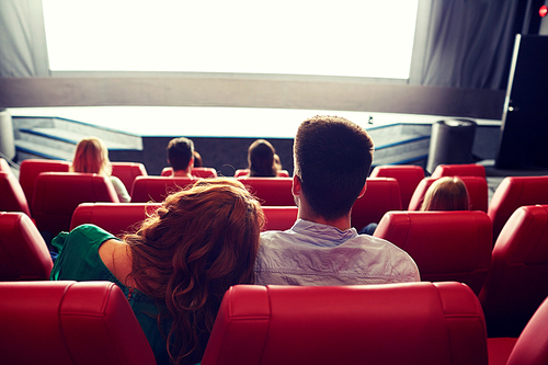 cinema, entertainment, leisure and people concept - happy, couple watching movie in theater from back