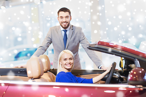 auto business, car sale, consumerism and people concept - happy couple buying cabrio car in auto show or salon over snow effect