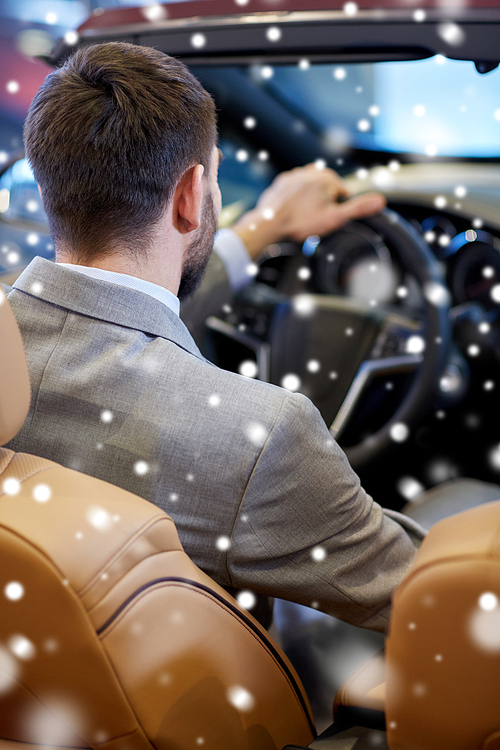 auto business, car sale, lifestyle and people concept - close up of man sitting in cabrio car at auto show or salon over snow effect