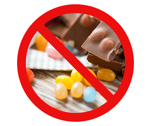 low carb diet, fattening and unhealthy eating concept - close up of jelly beans candies and chocolate behind no symbol or circle-backslash prohibition sign