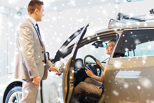 auto business, car sale, consumerism and people concept - happy woman with car dealer in auto show or salon over snow effect