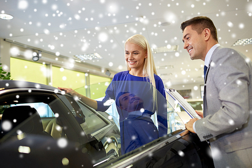auto business, car sale, consumerism and people concept - happy woman with car dealer in auto show or salon over snow effect