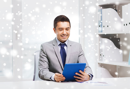 business, education, people and technology concept - smiling businessman with tablet pc computer in office over snow effect