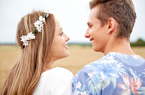 summer holidays, love, romance and people concept - happy smiling young hippie couple hugging outdoors