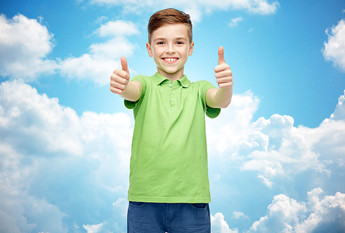 gesture, childhood, fashion and people concept - happy smiling boy in green polo t-shirt showing thumbs up over blue sky and clouds background