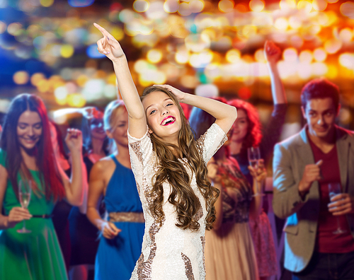 people, holidays and nightlife concept - happy young woman or teen girl in fancy dress with sequins and long wavy hair dancing at night club party over crowd and lights background