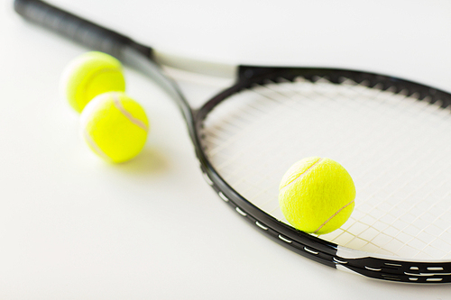 sport, fitness, healthy lifestyle and objects concept - close up of tennis racket with balls