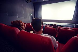 cinema, entertainment, leisure and people concept - couple watching movie in theater from back