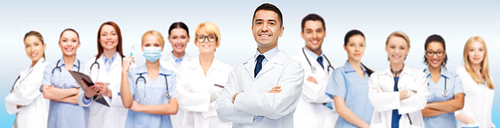 medicine, profession, teamwork and healthcare concept - international group of smiling medics or doctors with clipboard and stethoscopes over blue background