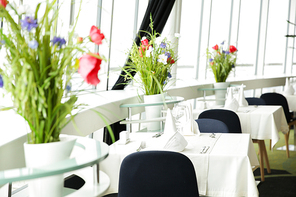 design, public place, furniture and interior concept - close up of decorated tables at restaurant