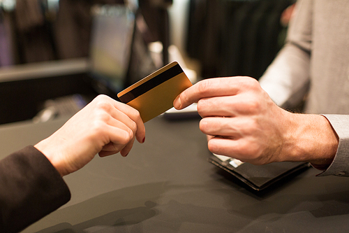 business, sale, payment and people concept - close up of customer hand giving credit card to seller or bank manager