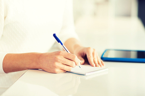 business, education, people and lifestyle concept - close up of woman hands with pen writing to notepad