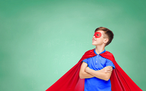 school, education, childhood, power and people concept - happy boy in red super hero cape and mask over green chalk board background
