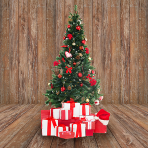 holidays, winter and celebration concept - christmas tree and presents over wooden room background
