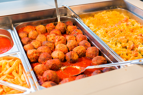 food, catering, self-service and eating concept - close up of meatballs and other dishes on metallic tray
