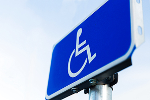 traffic laws and highway code concept - close up of road sign for disabled outdoors