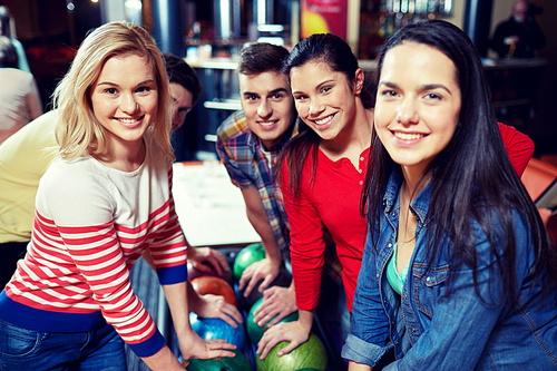 people, leisure, sport, friendship and entertainment concept - happy friends in bowling club