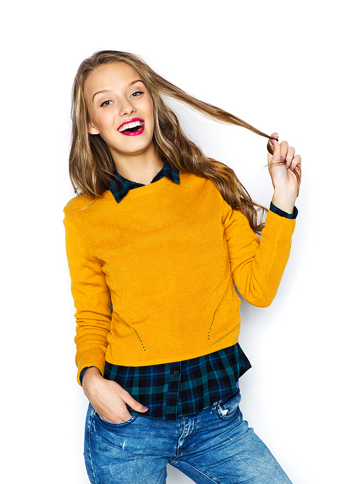 people, style, hairstyle and fashion concept - happy young woman or teen girl in casual clothes holding her hair strand