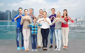 gesture, family, generation and people concept - group of smiling men, women and boy showing heart shape hand sign over singapore city waterside background