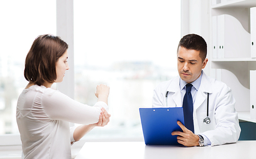 medicine, health care and people concept - young woman showing elbow to doctor with clipboard and meeting at hospital