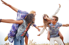 nature, summer, youth culture and people concept - happy young hippie friends having fun on cereal field