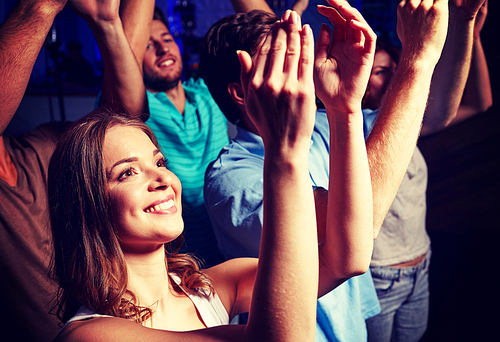 party, holidays, celebration, nightlife and people concept - smiling friends applauding at concert in club
