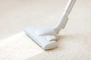 cleaning and home concept - close up of male hoovering carpet