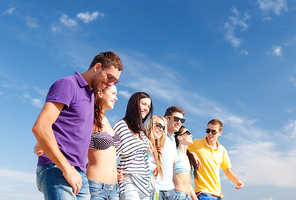 summer holidays, vacation, tourism, travel and people concept - group of happy friends walking along beach