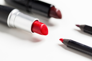 cosmetics, makeup and beauty concept - close up of two open lipsticks and lip pencils