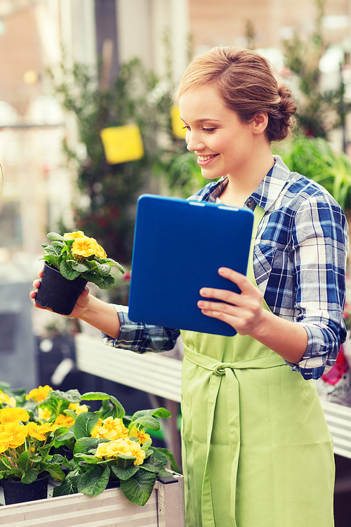 people, gardening, technology and profession concept - happy woman or gardener with tablet pc computer and flowers in greenhouse