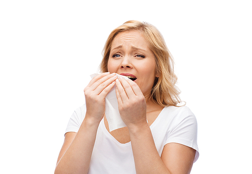 people, healthcare, rhinitis, cold and allergy concept - unhappy woman with paper napkin sneezing